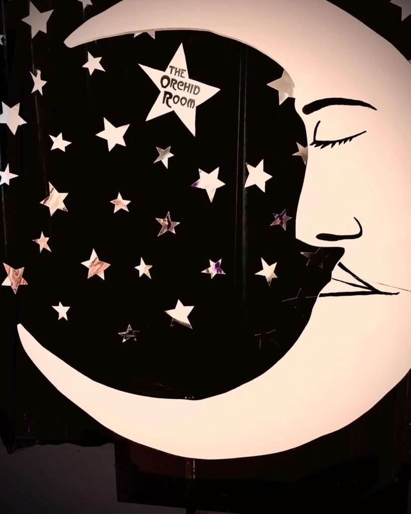 Hand-painted crescent moon and stars backdrop at The Orchid Room Margate, a music video location, with the venue name set into one star