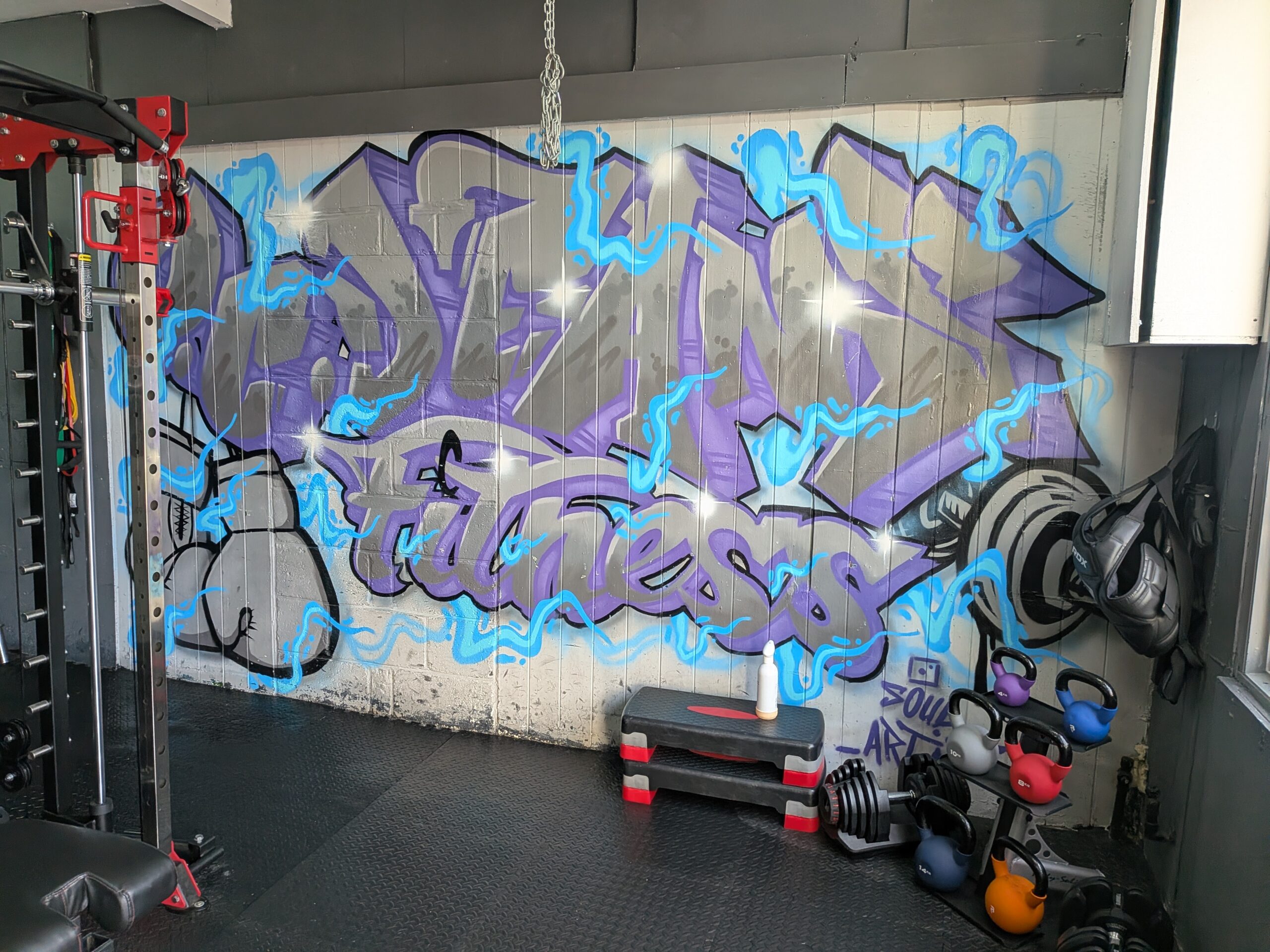 Private gym with power rack, punch bag, and graffiti wall at O.C. Dean's Fitness, Margate