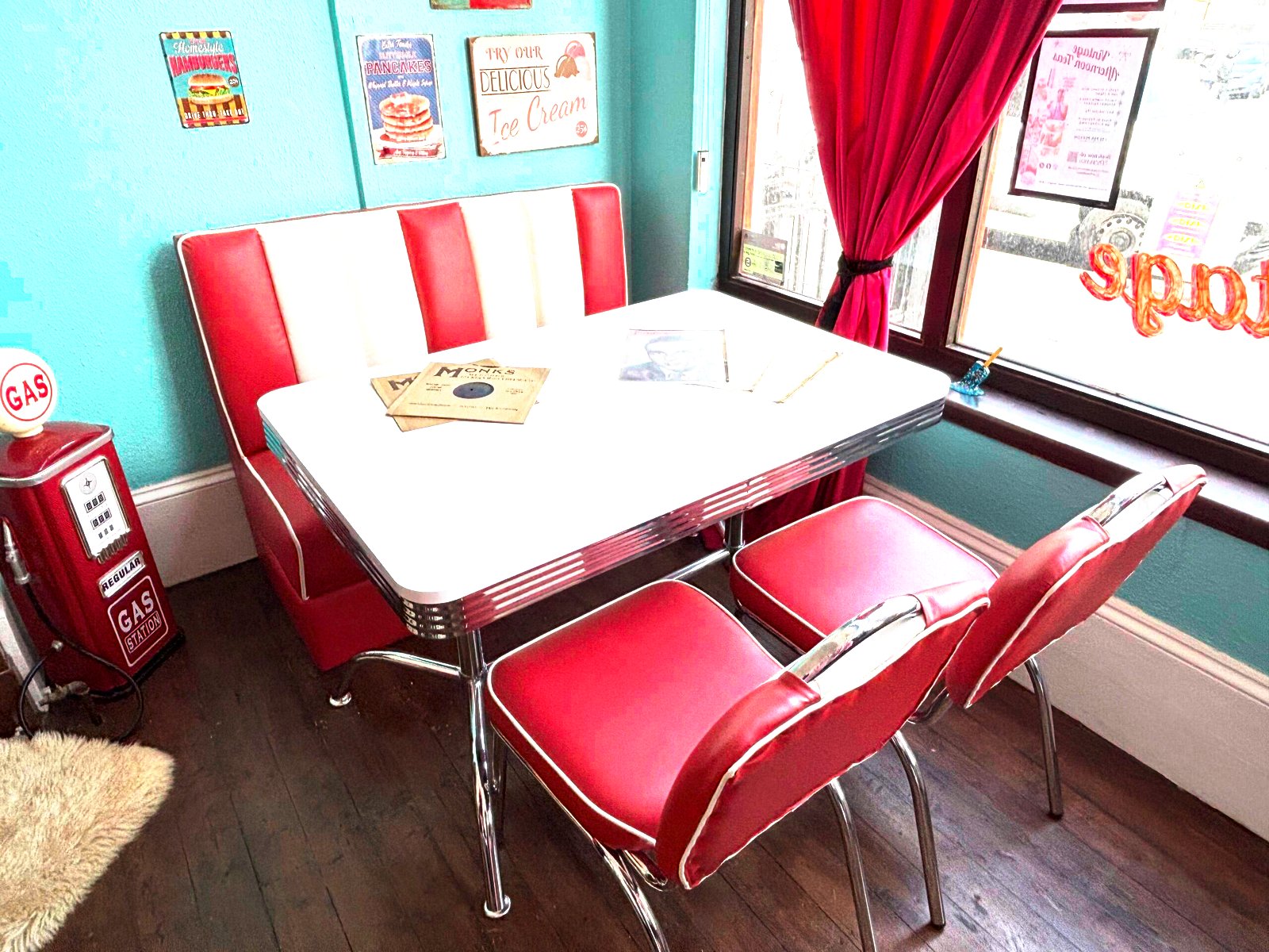 1950s American diner set at Le Keux Vintage Margate, pink and white booth, chrome Formica table, retro gas pump and vintage tin signs