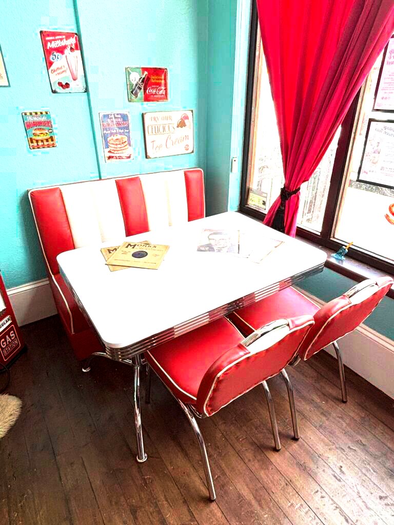 Retro diner booth with red and white seating and natural window light at Le Keux Vintage, Cliftonville