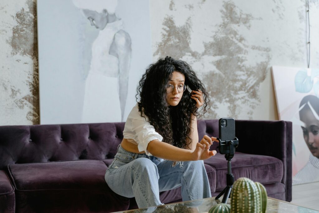 Content creator filming on a smartphone tripod in a characterful residential interior with distressed plaster walls in Kent