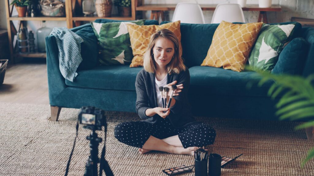  UGC content creator filming with a tripod in a characterful interior space with velvet sofa and textured walls 