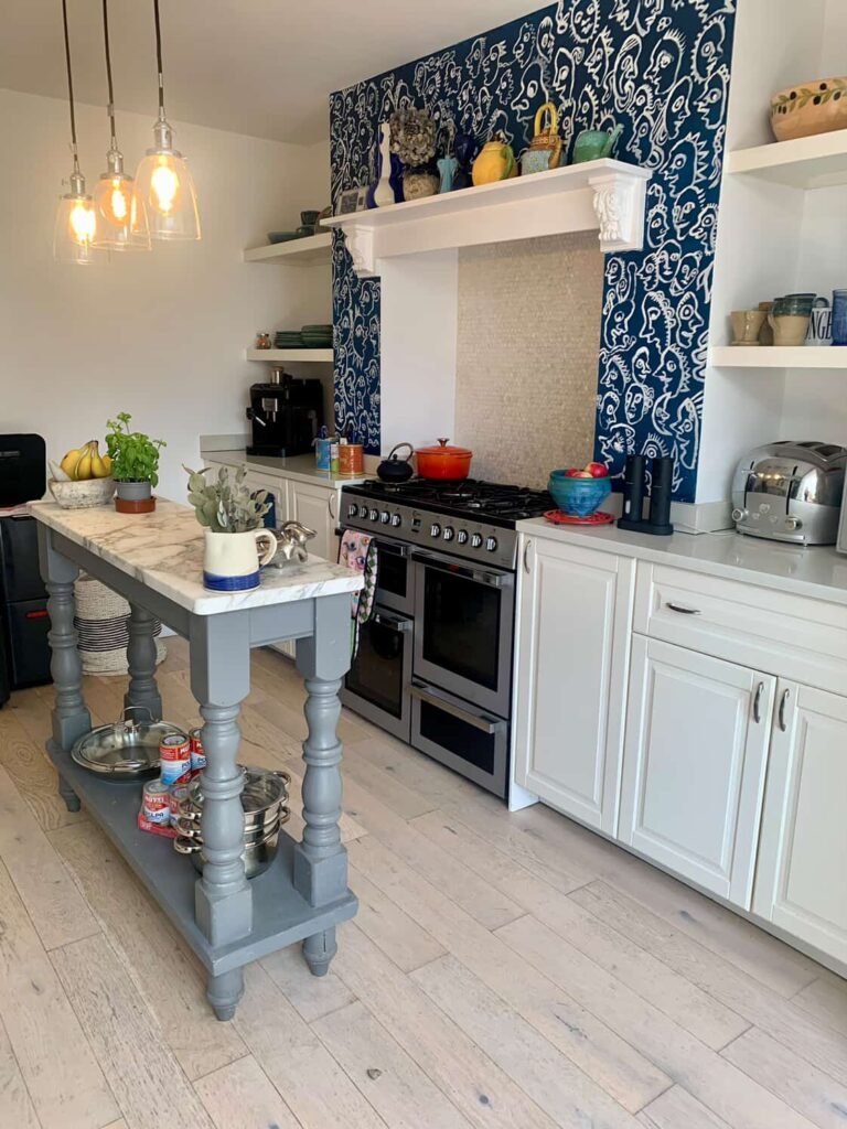 Marble-topped kitchen island at The Peacock House Margate under glass pendant lights with a pine dresser behind