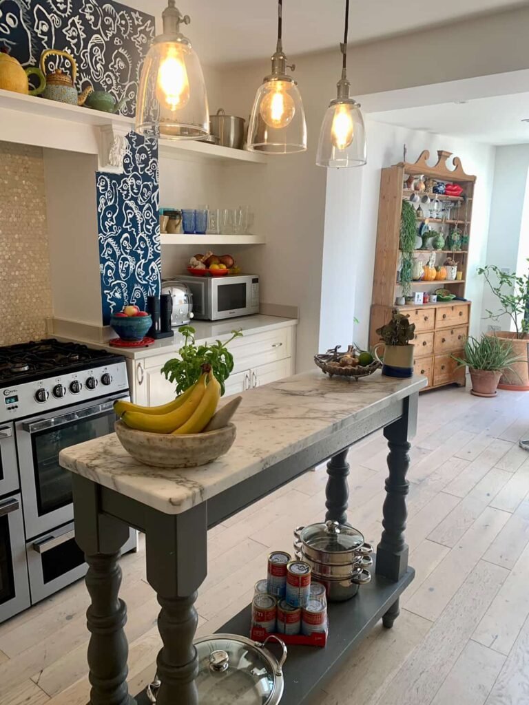 Bright sunroom kitchen at The Peacock House Margate with skylight, marble island and glazed doors to the garden