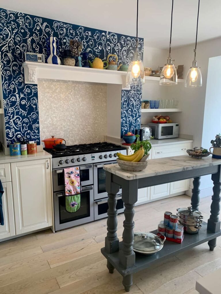 Range cooker at The Peacock House Margate framed by navy face-print feature wallpaper and a mother of pearl splashback