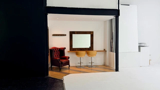 Hair and makeup preparation area with mirror, stools and leather chair inside Fire Eye Land